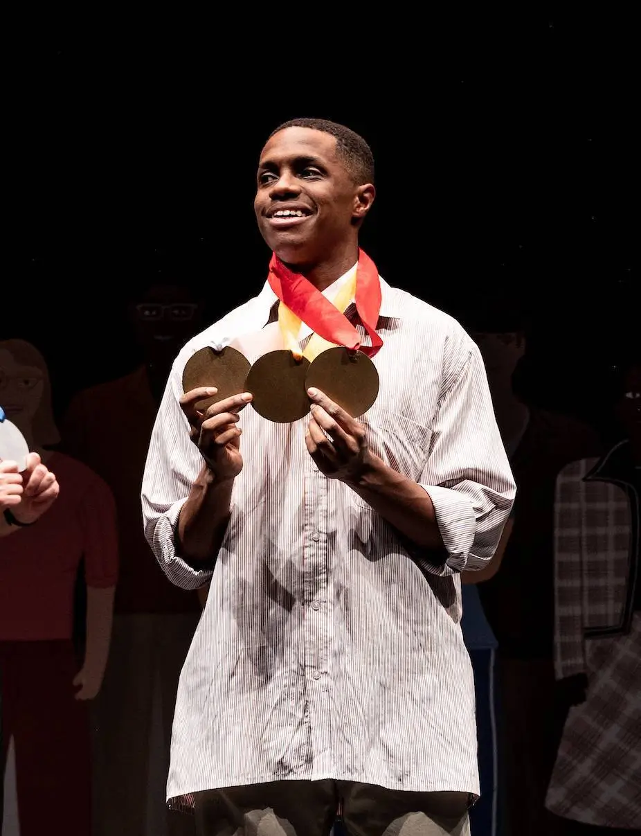 aaron corbett holding medals.webp