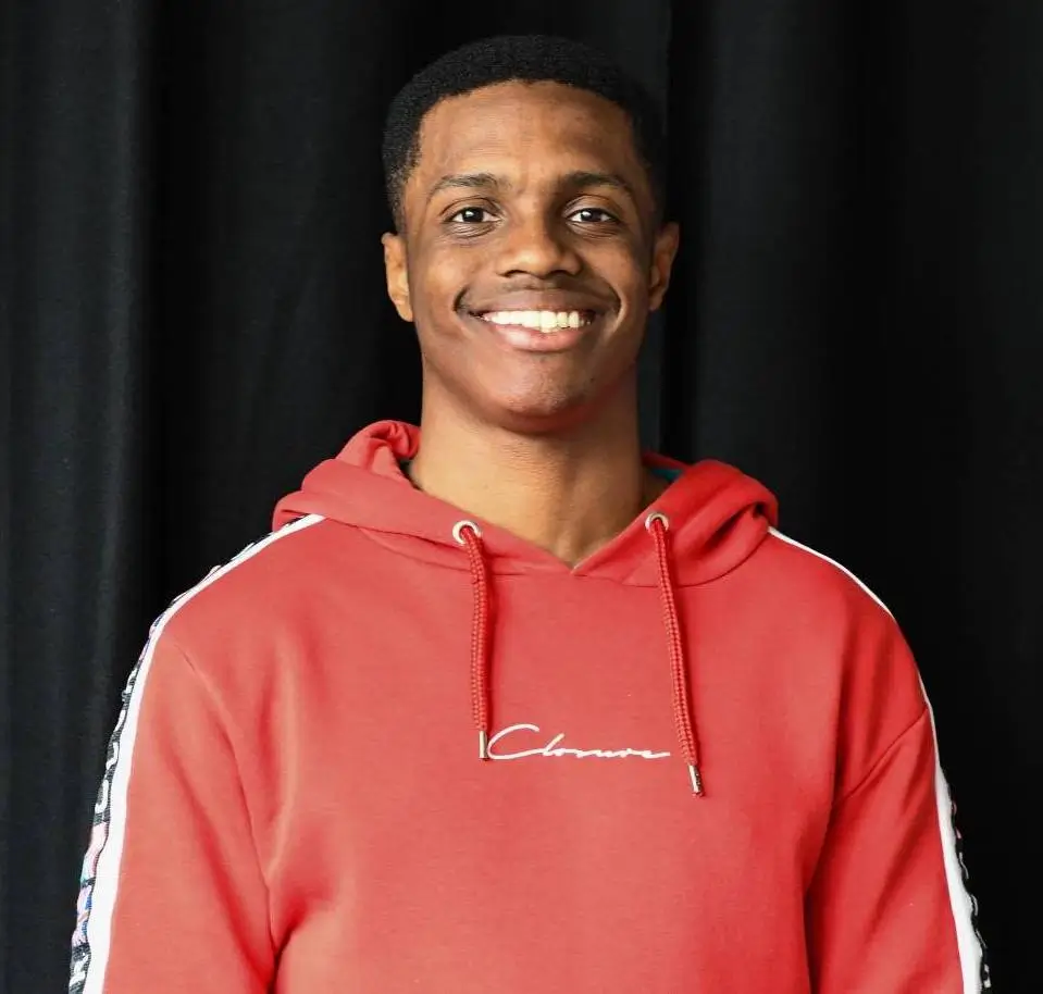 aaron corbett smiling in a red hoodie.webp